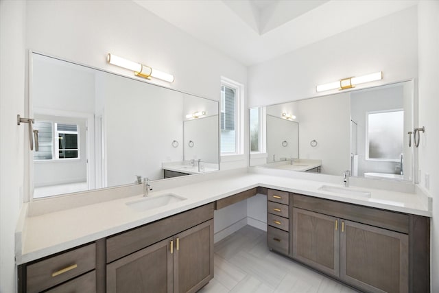 full bathroom featuring double vanity, a sink, and toilet