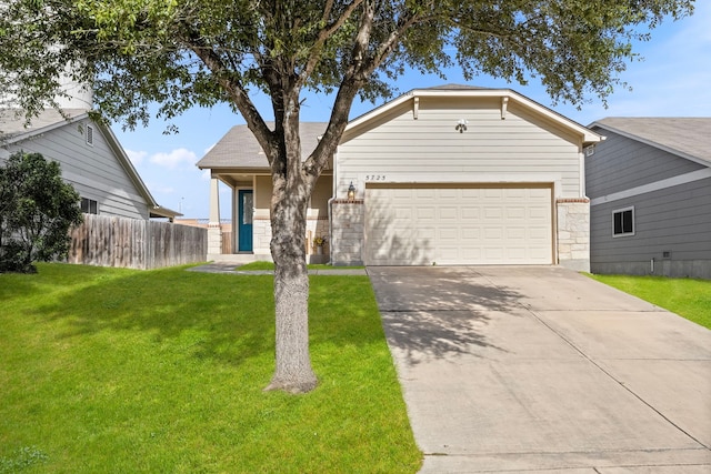 single story home with concrete driveway, an attached garage, a front yard, fence, and stone siding