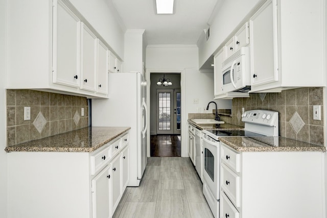 kitchen featuring decorative backsplash, ornamental molding, white cabinets, a sink, and white appliances