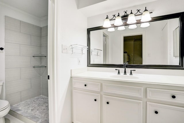 full bathroom featuring a tile shower, vanity, and toilet