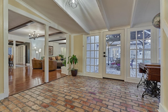 interior space featuring brick floor, beamed ceiling, and an inviting chandelier