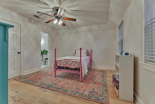 bedroom featuring a ceiling fan, wood-type flooring, visible vents, and baseboards