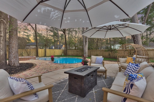 patio terrace at dusk featuring an outdoor living space with a fire pit, a fenced backyard, a fenced in pool, and an in ground hot tub