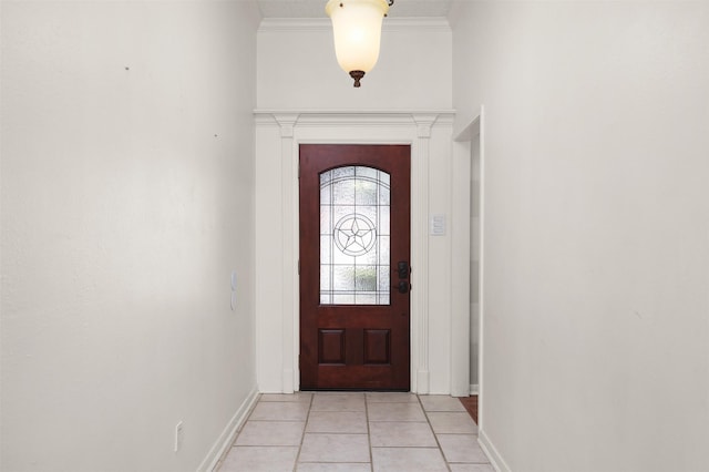 entryway featuring baseboards, ornamental molding, and light tile patterned flooring