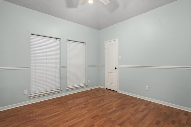 unfurnished room featuring ceiling fan, wood finished floors, and baseboards