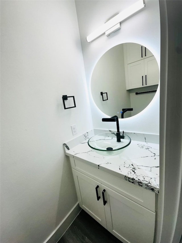 bathroom with wood finished floors, vanity, and baseboards