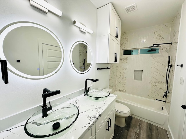 full bathroom with toilet, visible vents, a sink, and wood finished floors