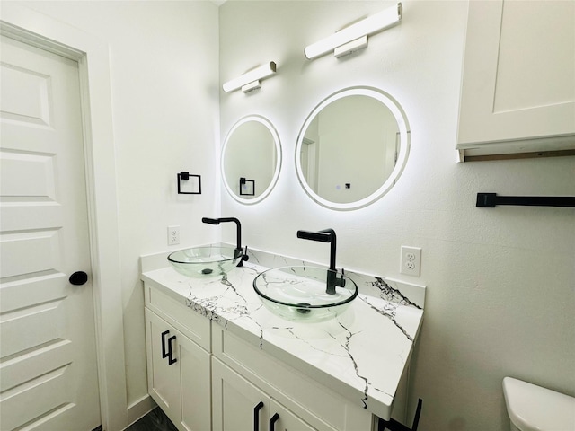 full bathroom featuring double vanity, toilet, and a sink