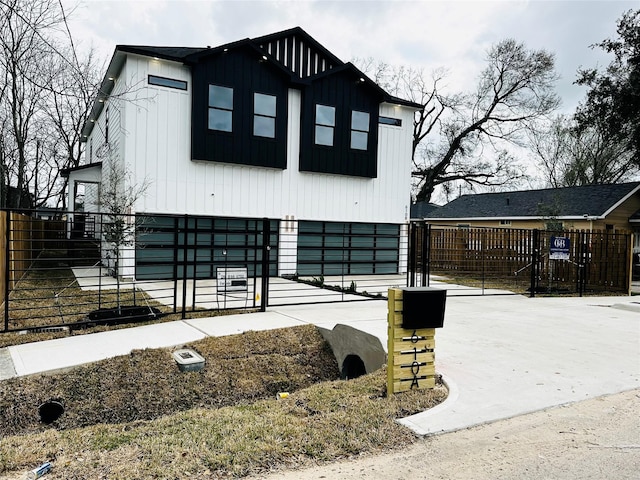 view of front of home with a garage, concrete driveway, and fence