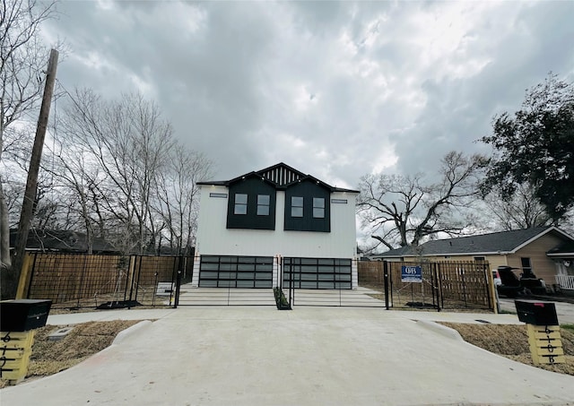 view of home's exterior with a gate, fence, and concrete driveway