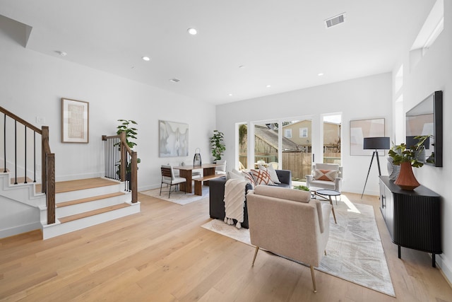 living room with light wood-style flooring, stairway, visible vents, and recessed lighting