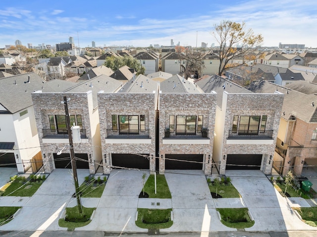 view of property with concrete driveway, an attached garage, and a residential view