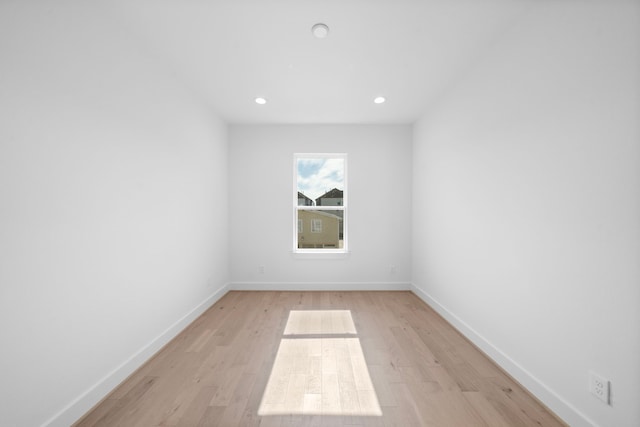 spare room featuring light wood finished floors, recessed lighting, and baseboards