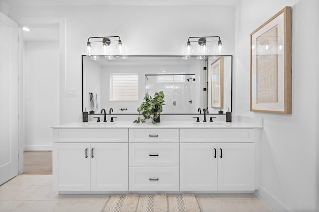 full bathroom with marble finish floor, double vanity, a stall shower, and a sink