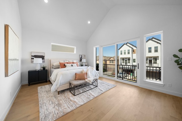 bedroom with access to exterior, baseboards, high vaulted ceiling, and light wood finished floors