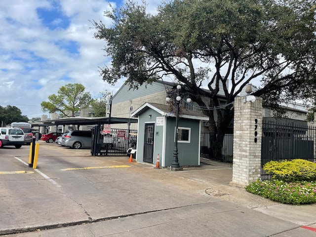 covered parking lot featuring fence