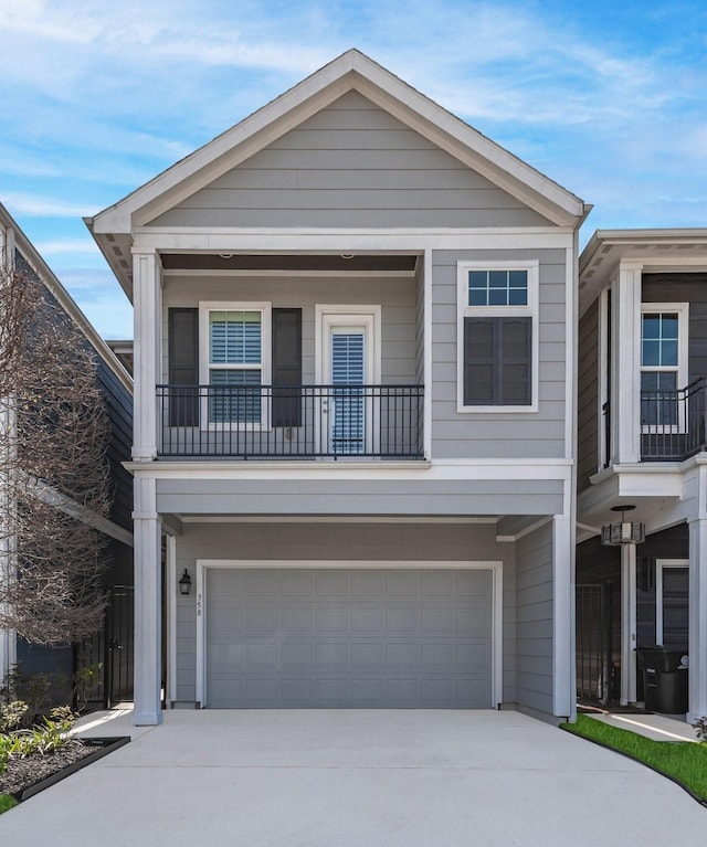 view of front of property with driveway, an attached garage, and a balcony