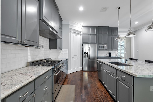 kitchen featuring appliances with stainless steel finishes, a sink, gray cabinetry, and ornamental molding