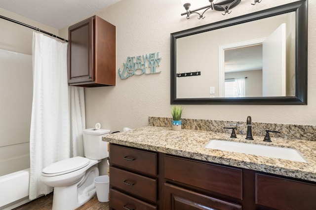 full bath with a textured wall, vanity, toilet, and wood finished floors