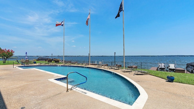 community pool featuring a patio, a water view, and fence