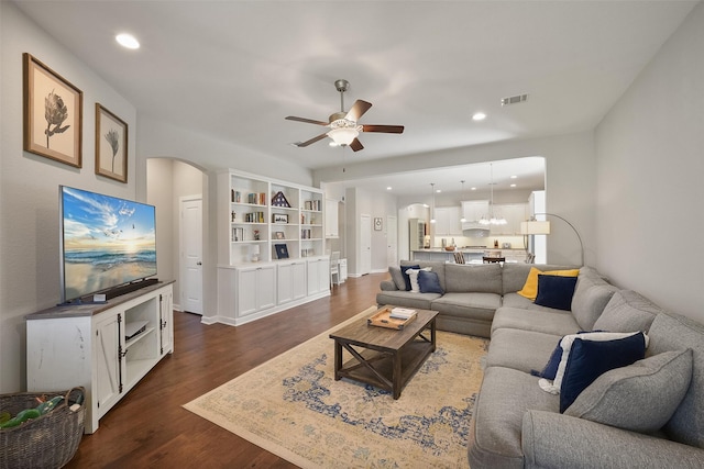 living room with visible vents, arched walkways, dark wood finished floors, a ceiling fan, and recessed lighting