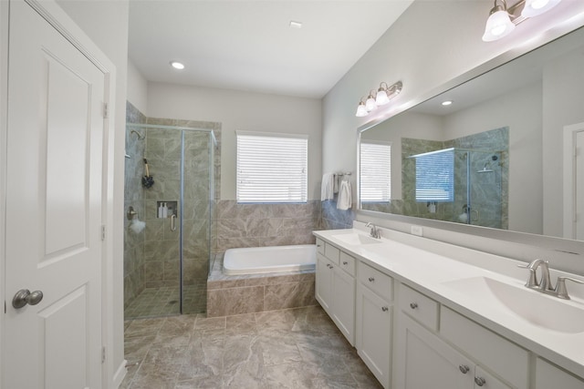 full bathroom featuring a stall shower, a garden tub, and a sink