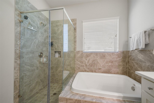 bathroom featuring a stall shower, vanity, and a bath