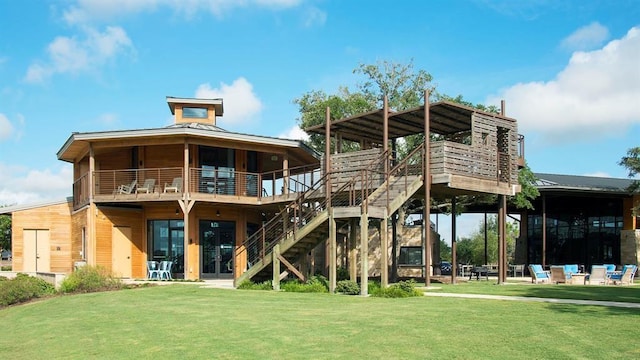 back of house featuring a standing seam roof, stairs, metal roof, and a lawn