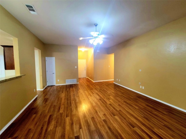 unfurnished room with visible vents, a ceiling fan, baseboards, and wood finished floors