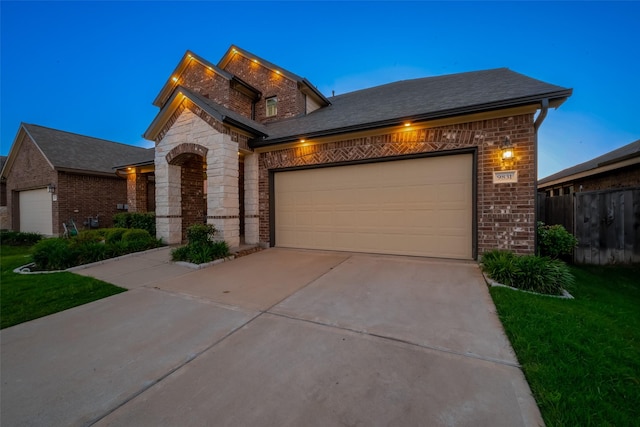 view of front of home with a shingled roof, concrete driveway, a garage, stone siding, and brick siding