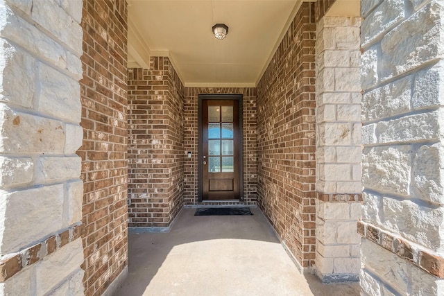 view of exterior entry with brick siding