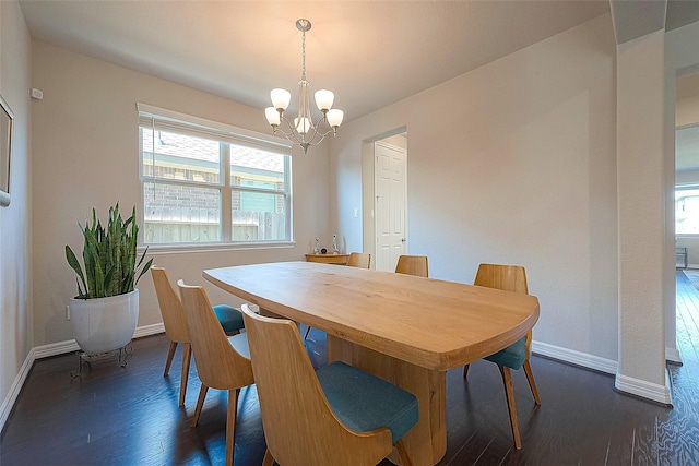 dining room with dark wood-style floors, a notable chandelier, and baseboards