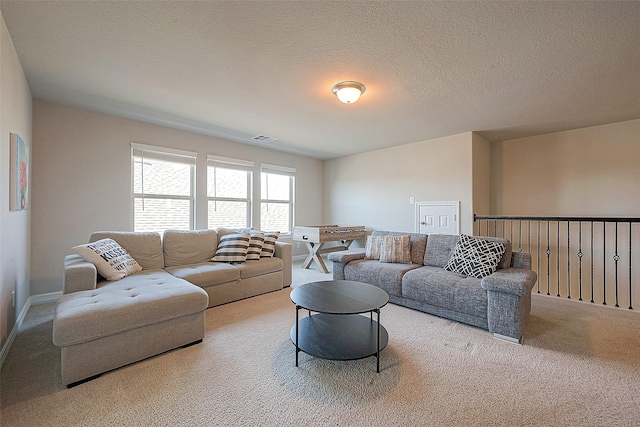 living room with carpet flooring, visible vents, and a textured ceiling