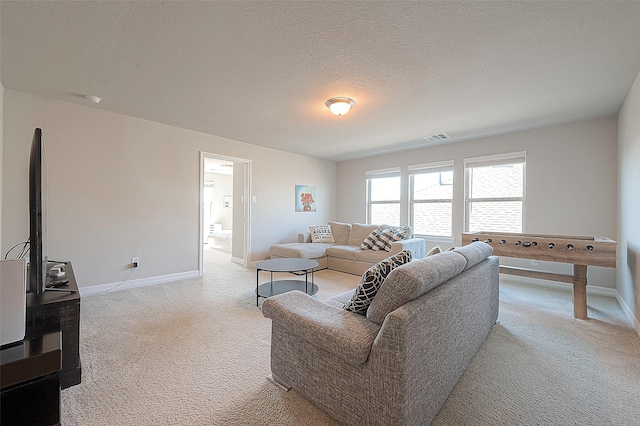 living area with a textured ceiling, baseboards, visible vents, and light carpet