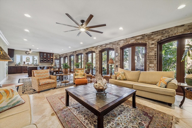 living area featuring recessed lighting, plenty of natural light, a ceiling fan, and crown molding