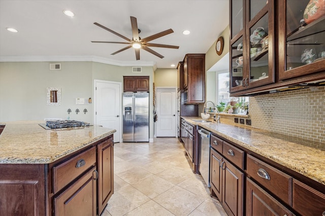 kitchen featuring light stone counters, visible vents, appliances with stainless steel finishes, decorative backsplash, and crown molding