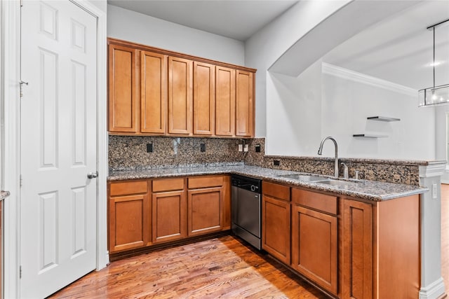 kitchen featuring dishwasher, a peninsula, brown cabinets, and a sink