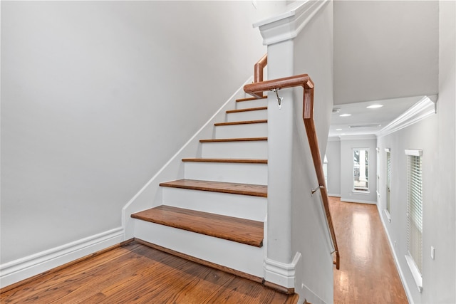 stairs with recessed lighting, baseboards, wood finished floors, and crown molding