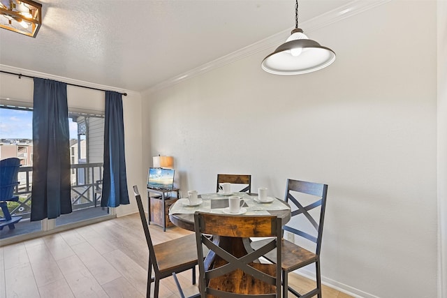 dining space featuring crown molding, a textured ceiling, baseboards, and wood finished floors