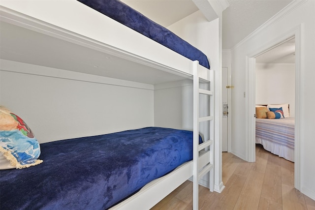 bedroom featuring ornamental molding and wood finished floors