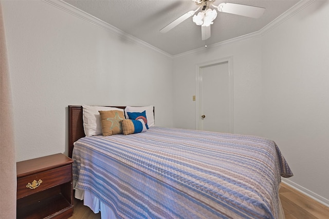 bedroom with ceiling fan, baseboards, wood finished floors, and crown molding