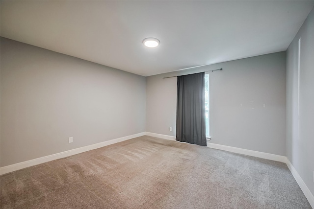 unfurnished room with carpet floors and baseboards