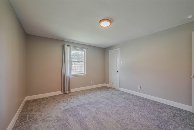 spare room featuring carpet and baseboards