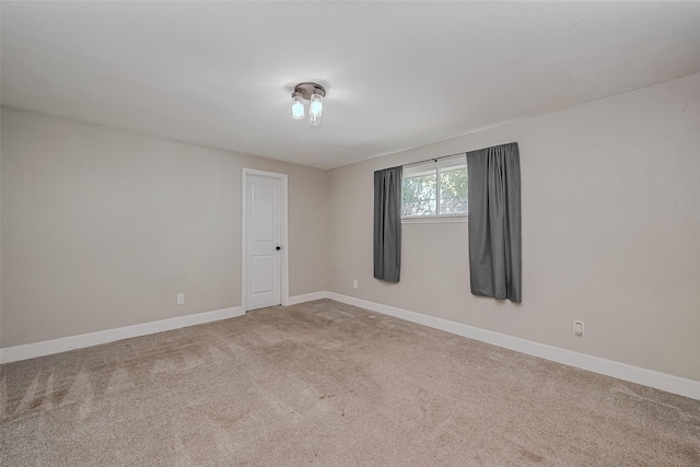 unfurnished room with carpet and baseboards