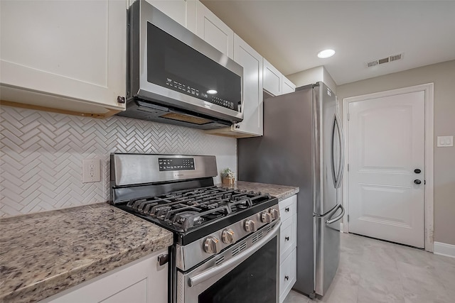 kitchen with stainless steel appliances, decorative backsplash, visible vents, and white cabinets