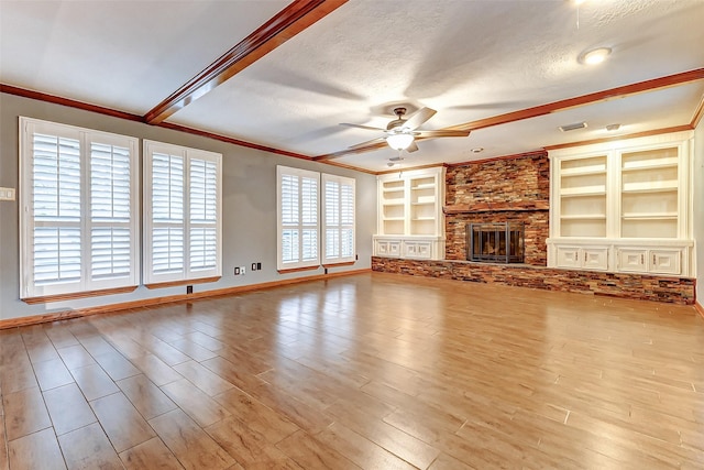 unfurnished living room featuring built in features, a ceiling fan, wood finished floors, a textured ceiling, and a fireplace