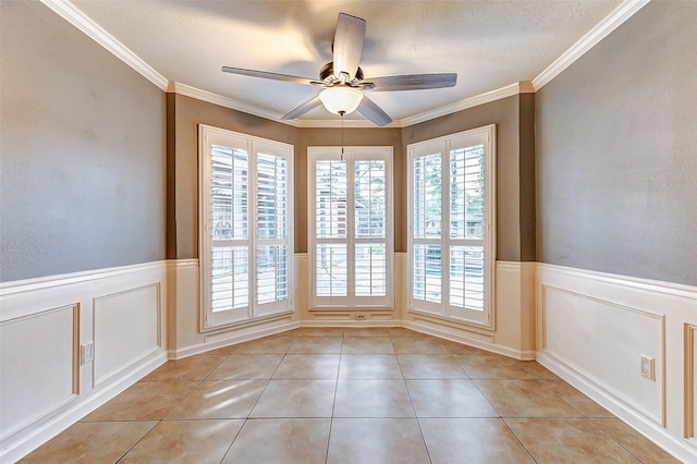 unfurnished dining area with ornamental molding, wainscoting, and light tile patterned flooring