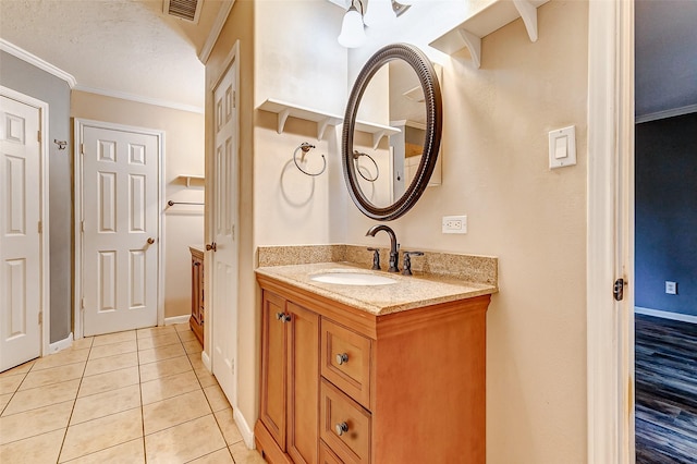 bathroom with visible vents, baseboards, ornamental molding, tile patterned flooring, and vanity