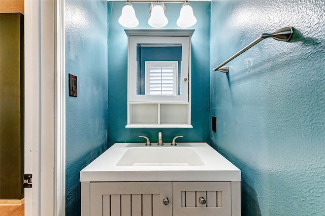 bathroom featuring a textured wall and vanity