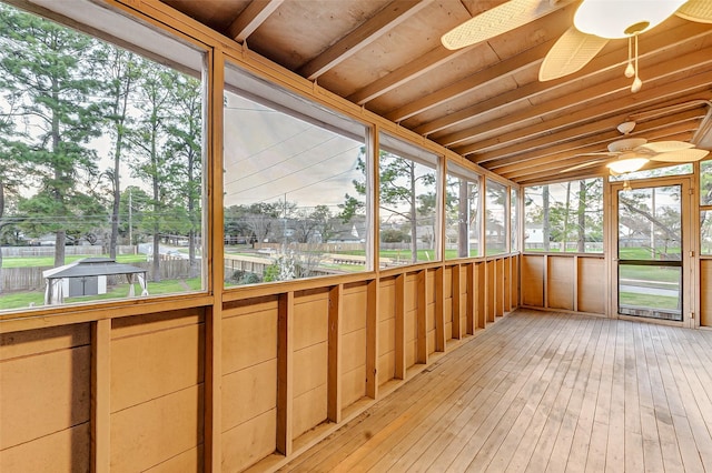 unfurnished sunroom featuring a wealth of natural light, vaulted ceiling, and a ceiling fan